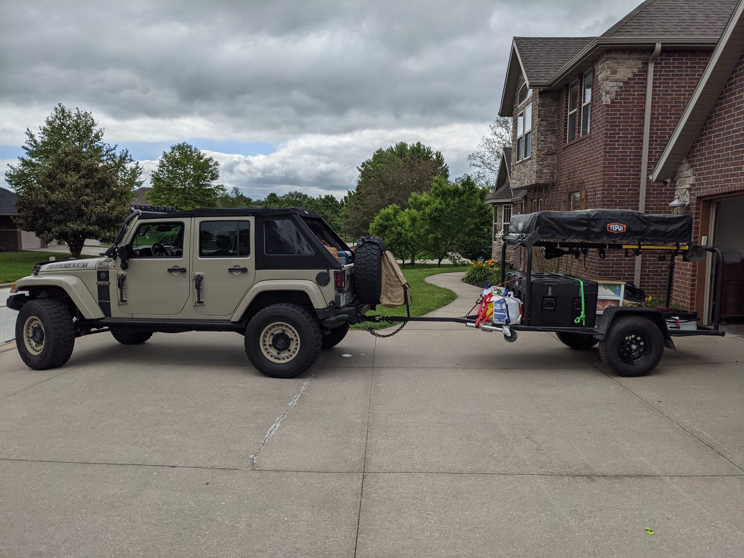 Twain Trailers trailer with Tepui rooftop tent towed by tan Jeep Wrangler